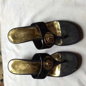 Black Coach sandals with gold hardware.